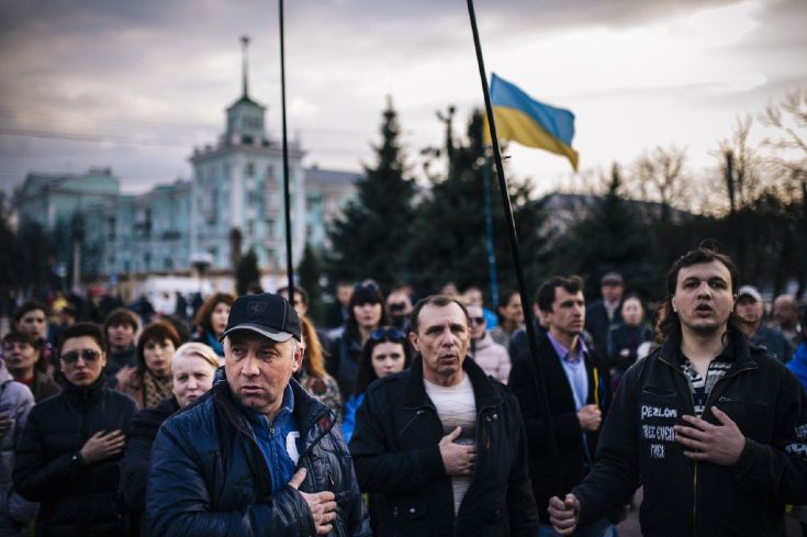 Люди поют гимн Украины во время демонстрации в поддержку новых властей Украины в Луганске. © IMITAR DILKOFF/AFP/Getty Images  
