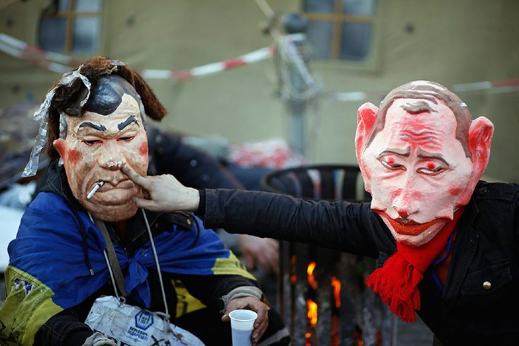 Люди на Майдане в масках Путина и Януковича. © Marko Djurica/Reuters