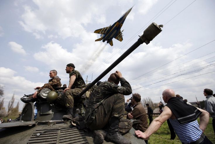 Истребитель пролетает над блокированным местными жителями экипажем танка украинских войск. © scmp.com