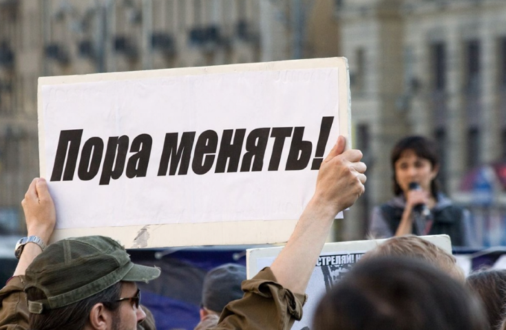 Протестующий с плакатом © komuna.org.ua