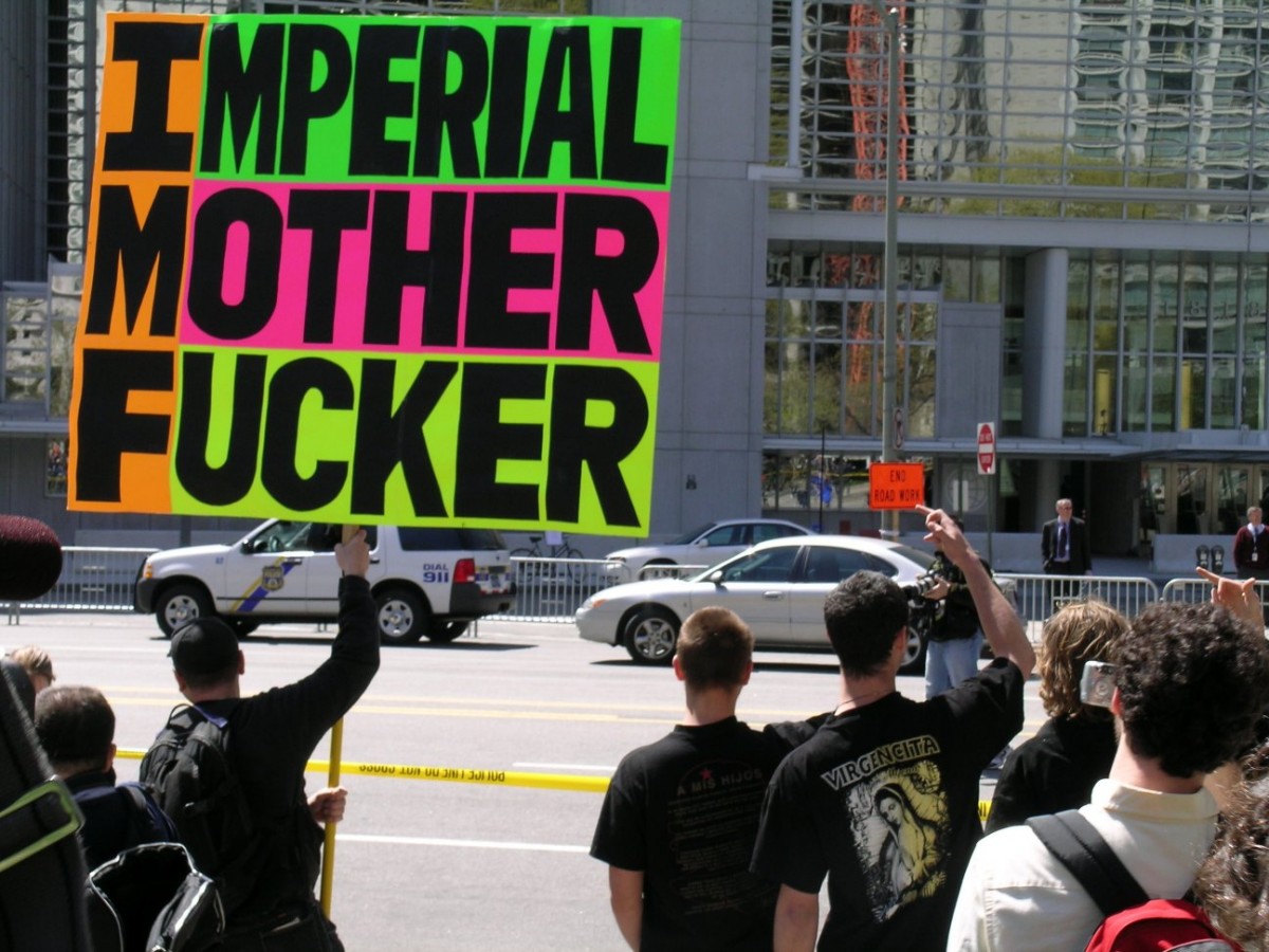 Надпись на плакате: "Империалистический ублюдок".