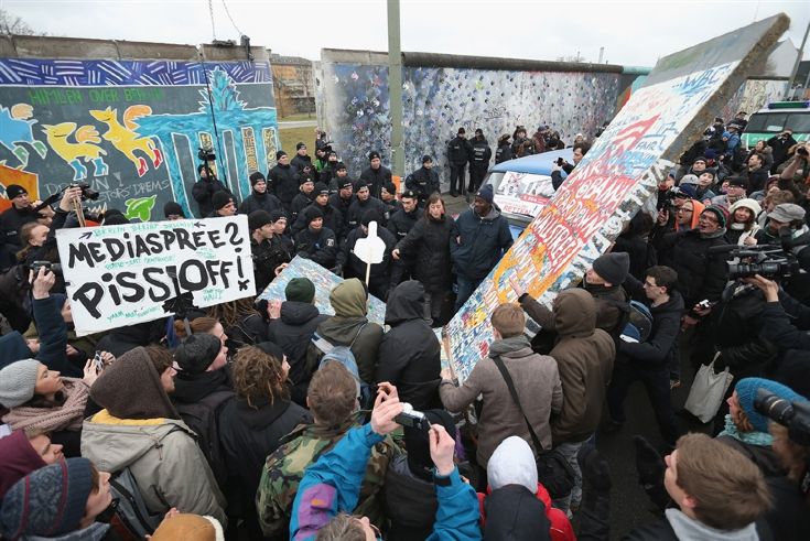 Полицейские блокируют демонстрантов, которые пытаются вернуть на место изъятую секцию Берлинской стены. © (Sean Gallup/Getty)