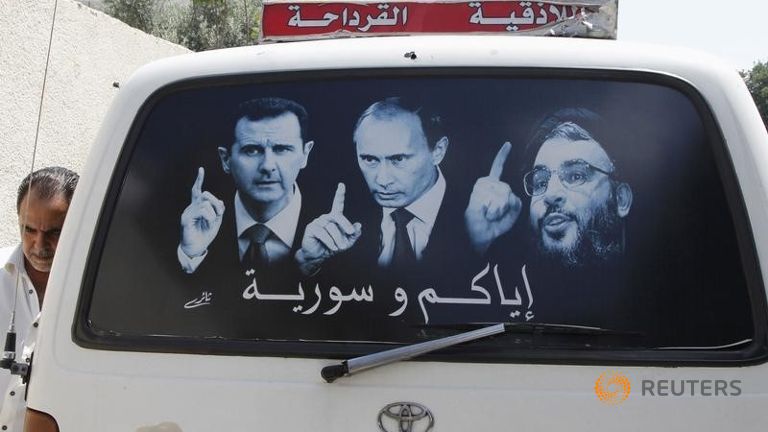 Постер с президентом Сирии Башаром Ассадом, президентом РФ Владимиром Путиным и главой Хезболла Хасан Насралла © REUTERS/Khaled al-Hariri